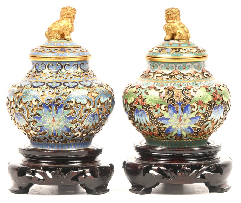 Een set van twee cloisonné dekselpotjes op houten sokkel.