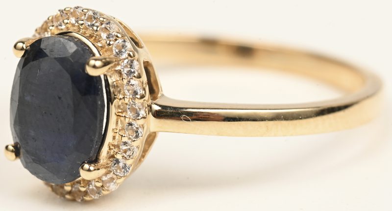 Een 14 kt geelgouden ring bezet met een centrale saffier van +- 1,63 ct. en briljanten met een gezamenlijk gewicht van +- 0,45 ct.