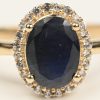 Een 14 kt geelgouden ring bezet met een centrale saffier van +- 1,63 ct. en briljanten met een gezamenlijk gewicht van +- 0,45 ct.