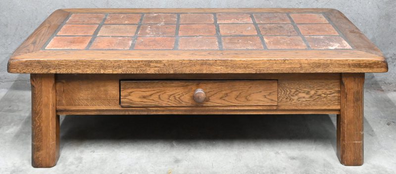 Een rustieke salontafel van massieve eik, met terra-cotta tegelblad.