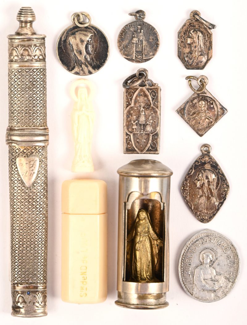 Een lotje religieus bestaande uit 6 hangertjes waaronder zilveren, 2 kokertjes met een madonna, een penning en een kokertje met hierop het een hart.