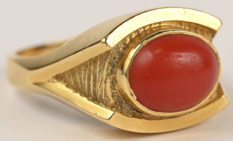 Een 18 kt geelgouden ring bezet met een koraal.