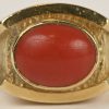 Een 18 kt geelgouden ring bezet met een koraal.