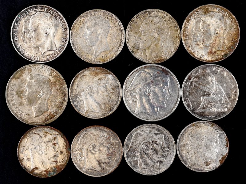 Twaalf zilveren muntstukken van zilver waaronder: 1, 20 Frank muntstuk Albert Koning der Belgen 1934. 1, 20 Frank muntstuk Leopold 1935. 1, 50 Frank muntstuk, Mercurius Belgie 1950, 2 van 50 Frank, Baldvinvs - Fabiola, Belgica. Vijf 20 frank muntstukken, Mercurius Belgique 1950. En 500 Lire 1961. En een half Crown 1944.
