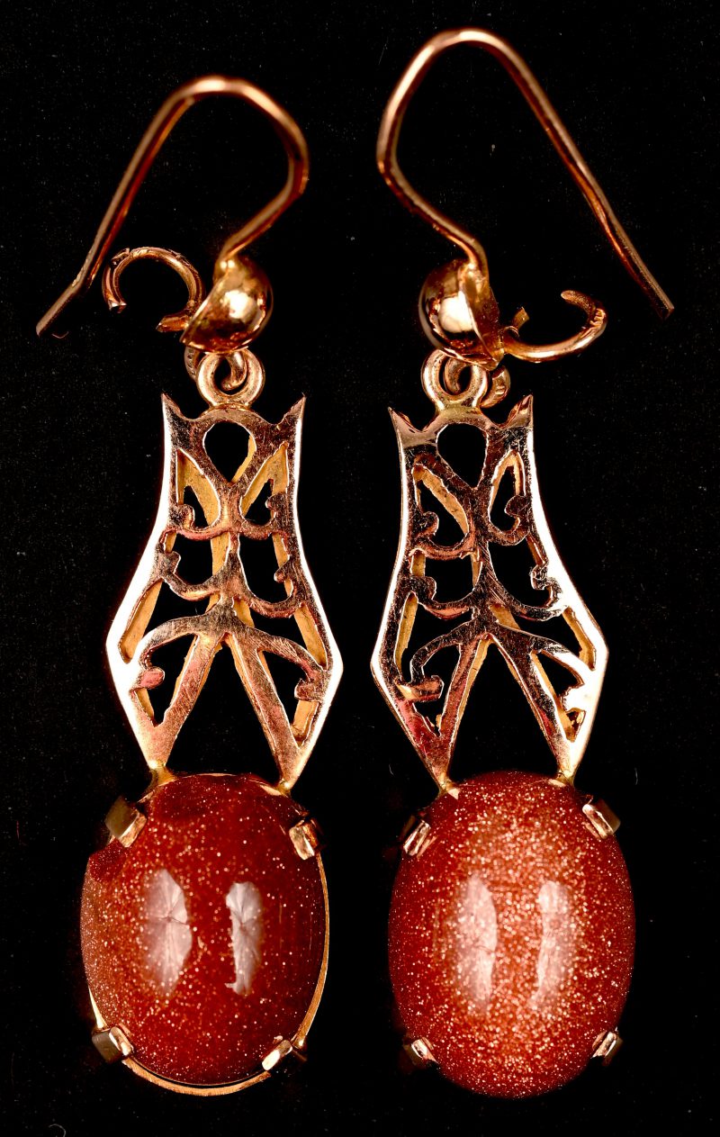 Een paar 18 kt rooskleurige gouden oorbellen bezet met cabochons van goudsteen.