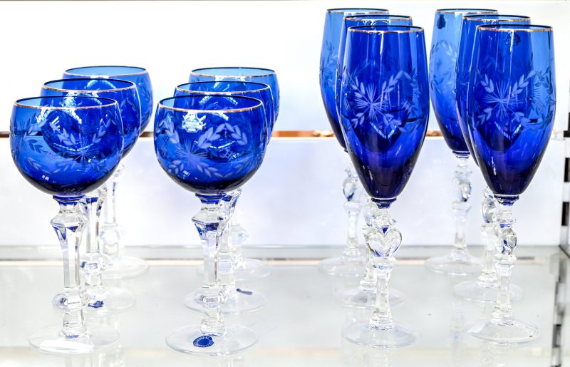 Een set van 6 wijn en 6 champagneglazen, van geslepen blauw kristal met een verguld randje.