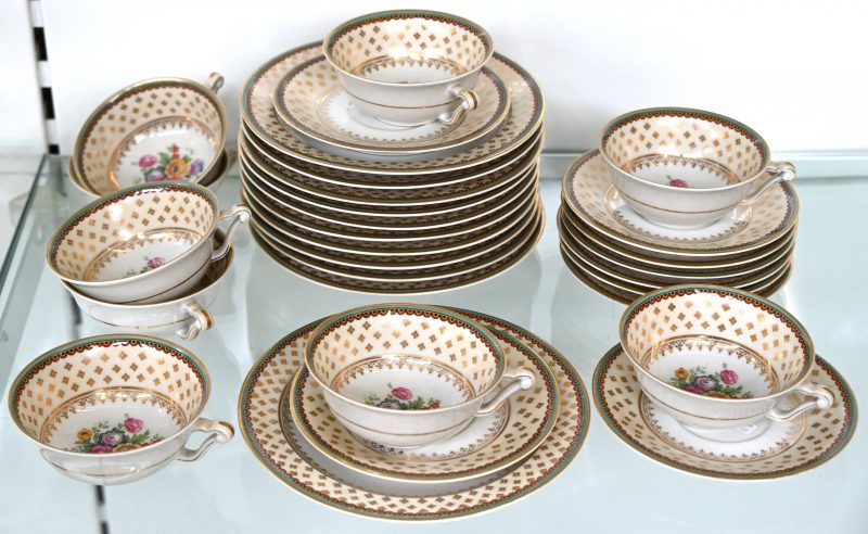 Een dessertserviesje van Limoges porselein met een decor van bloemen en gouden accenten. Bestaat uit 9 koffiekopjes, 9 schoteltjes en 11 bordjes.