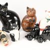Een lot van 25 kattenbeelden uit verschillende materialen, hout, kunststof en keramiek. De grote zwart keramische is gebarsten.