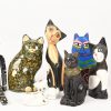 Een lot van 25 kattenbeelden uit verschillende materialen, hout, kunststof en keramiek. De grote zwart keramische is gebarsten.