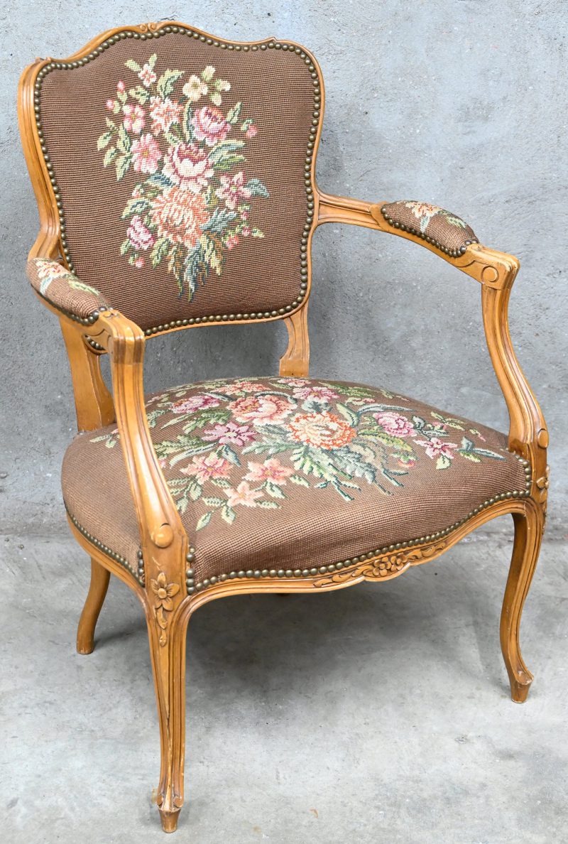 Een bukenhouten armstoel in Lodewijk XV-stijl. Bekleed met naaldwerk “petit point”.