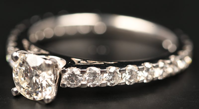 Een 18 kt witgouden ring bezet met een centrale briljant van 0,60 ct. GVS1 En briljanten met een gezamenlijk gewicht van 0,93 ct.