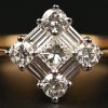 Een 18 kt wit- en geelgouden ring bezet met briljanten en baguetten met een gezamenlijk gewicht van 0,72 ct.