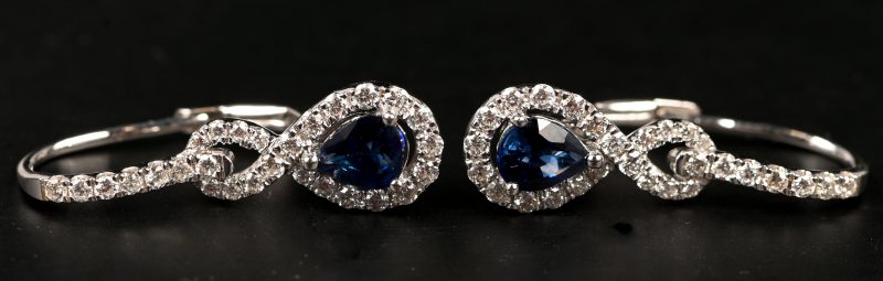 Een paar 18 kt witgouden oorbellen met briljanten met gezamenlijk gewicht van 0,48 ct. En twee saffieren gezamenlijk 0,64 ct.