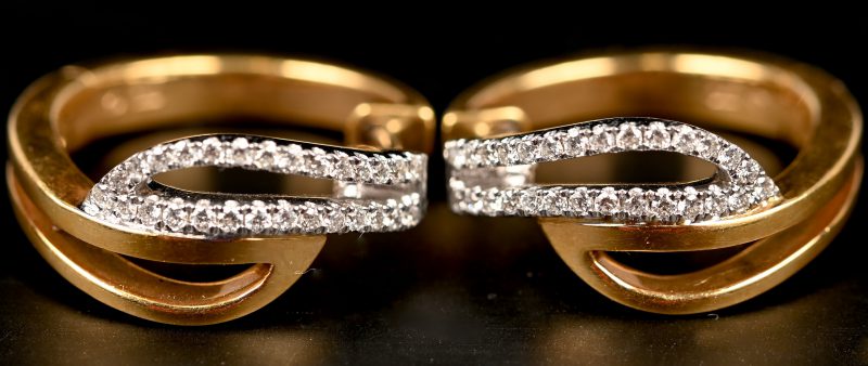 Een paar 18 kt wit- en geelgouden oorbellen met briljanten met gezamenlijk gewicht van 0,48 ct.