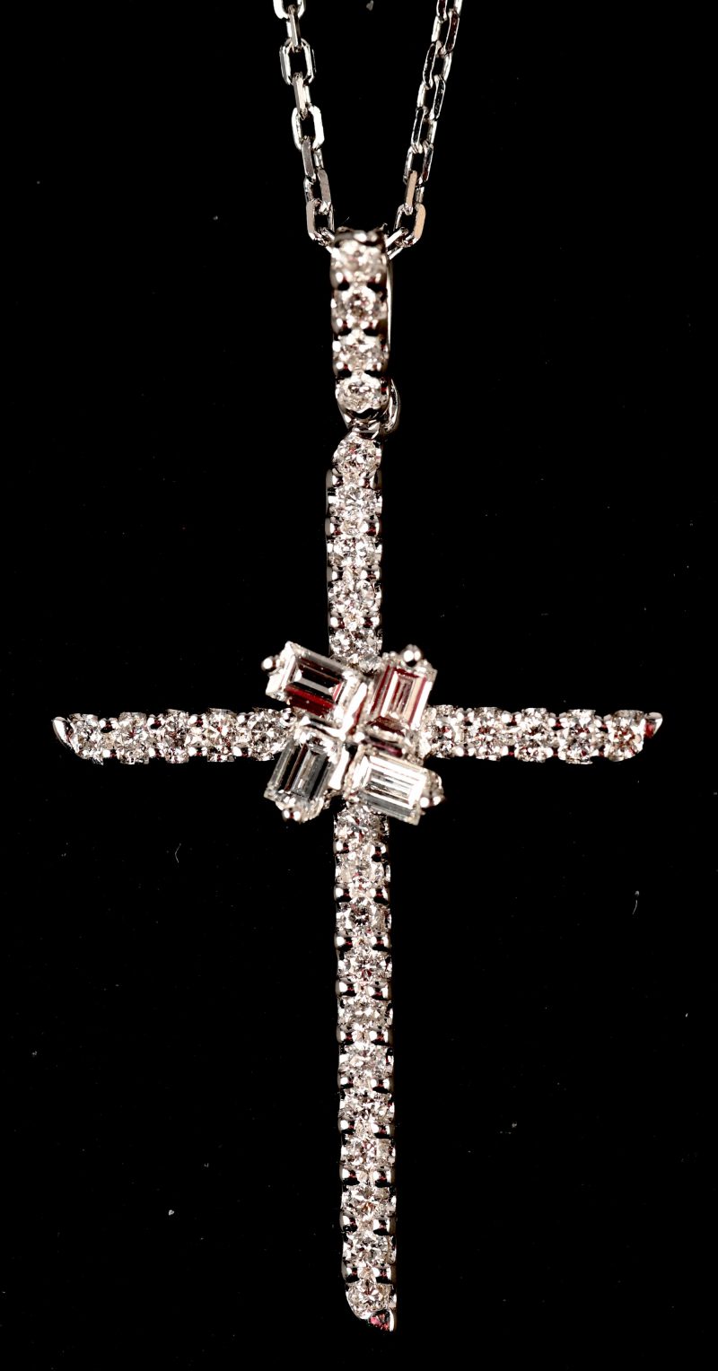 Een 18 kt witgouden ketting met crucifix hanger met briljanten en baguetten met een gezamenlijk gewicht van 0,52 ct.