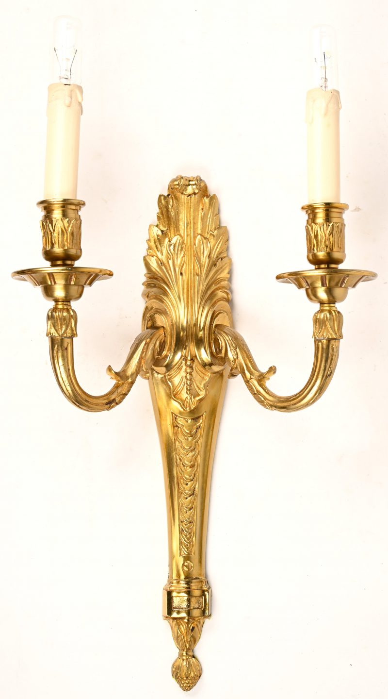 Zware bronzen wandlamp in Empirestijl, gevormd als een dubbele kandelaar.