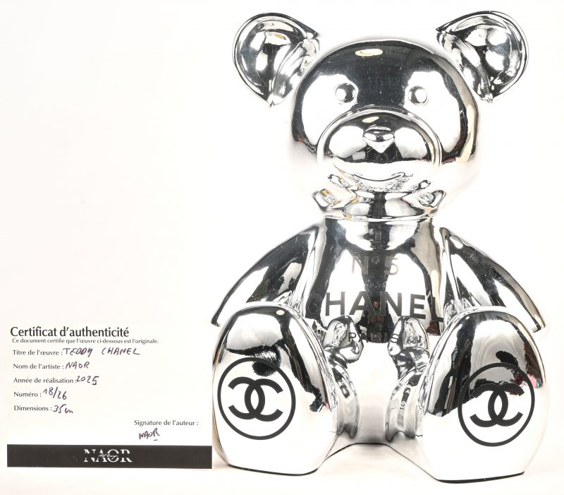 ‘Teddy Chanel’. Een zilverkleurig beeldje van een beer met het logo van het parfum Nr. 5 Chanel. Nr. 18 uit een oplage van 26 exemplaren. Met certificaat en originele doos. Getekend en genummerd.