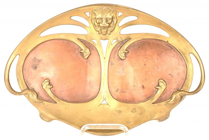 Een Art-Nouveau vide-poche, brons en rood koper, gedecoreerd met een leeuwenkop en klauwen. Onderaan de woorden ‘Real Bronze Geschützt’.