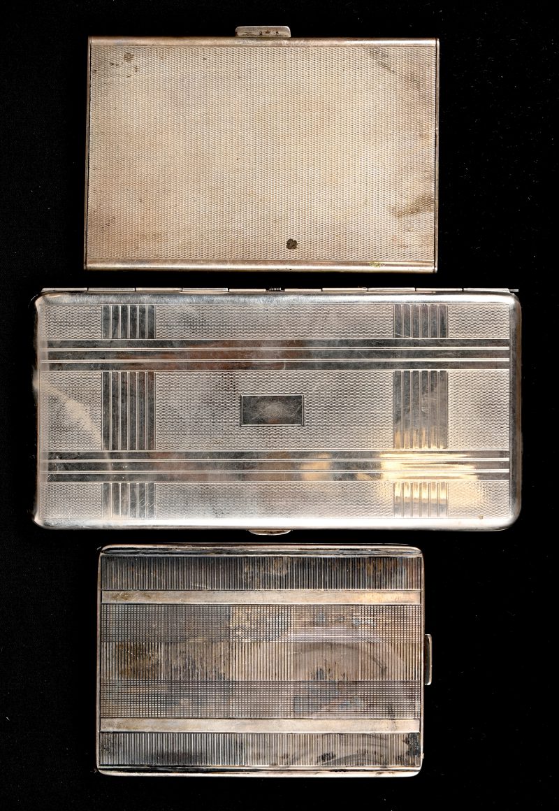 Een lot van 2 zilveren sigarettenkokers, 835 en 935‰, 130 gram en 190 gram, toegevoegd een verzilverd exemplaar.