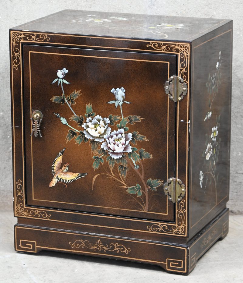 Een klein houten kastje in Chinees lakwerk met florale decoratie.