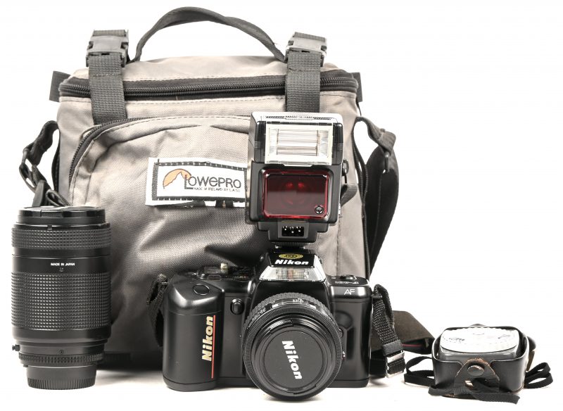 Een analoog fototoestel, Nikon F-401, te repareren (klep van filmrol sluit niet meer), met 2 lenzen: AF Nikkor 35-70mm - 1:3.3-4.5 en AF Nikkor 70-210mm - 1:4-5.6, flits, lichtmeter en tas met toebehoren.