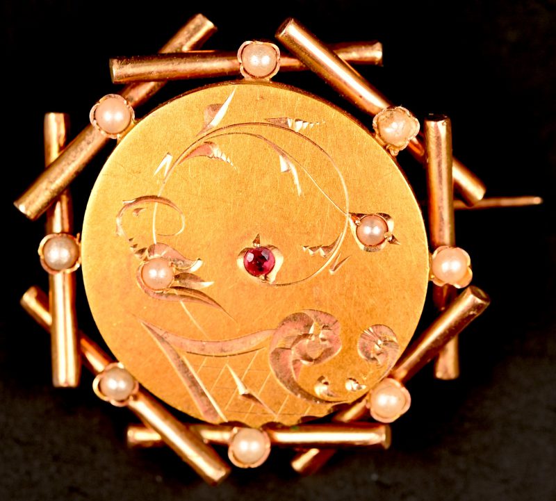 Een 14 kt geelgouden broche bezet met één robijntje en pareltjes.
