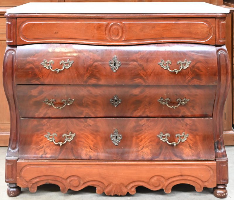 Een buikcommode met witmarmeren blad. Vijf laden waarvan twee ‘verborgen’, één onder het blad en één in de plint.