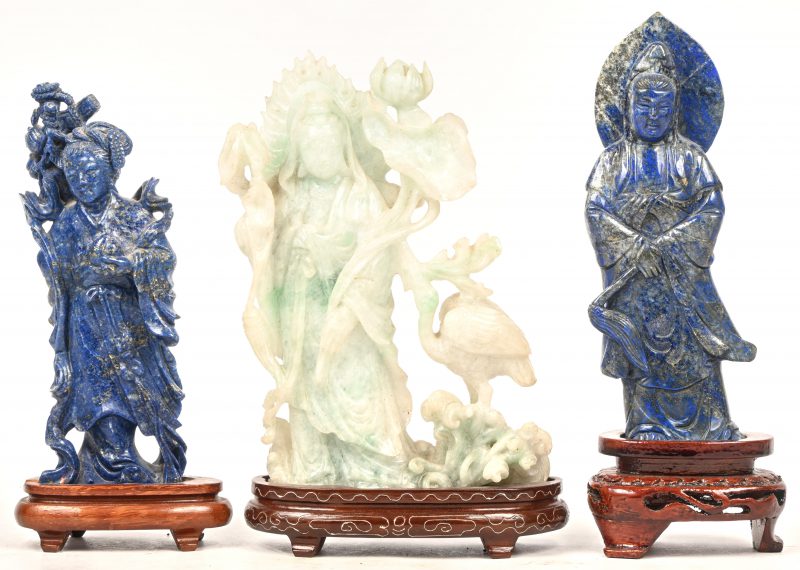 Drie Guanyin beeldjes op houten sokkeltje, 2 x lapis lazuli en 1 x jadeite.