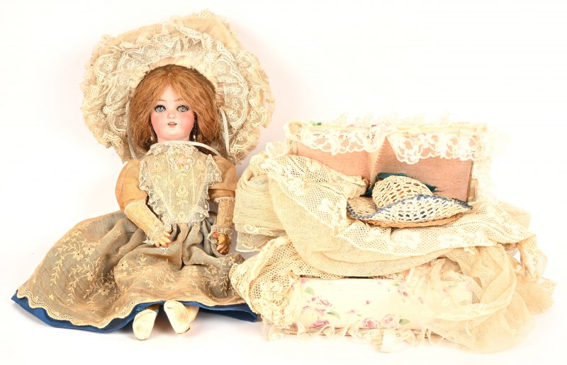 Een antieke pop met bewegende ogen, gemerkt Germany Simon & Halbig #4. Biscuit hoofdje met echt haar. In goede staat. Toegevoegd een doosje met kledij. Circa 1900.