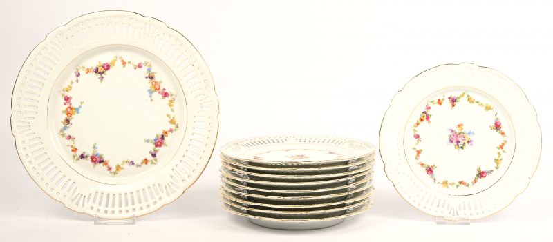 Een porseleinen borden set met floraal decor en opengewerkte rand.