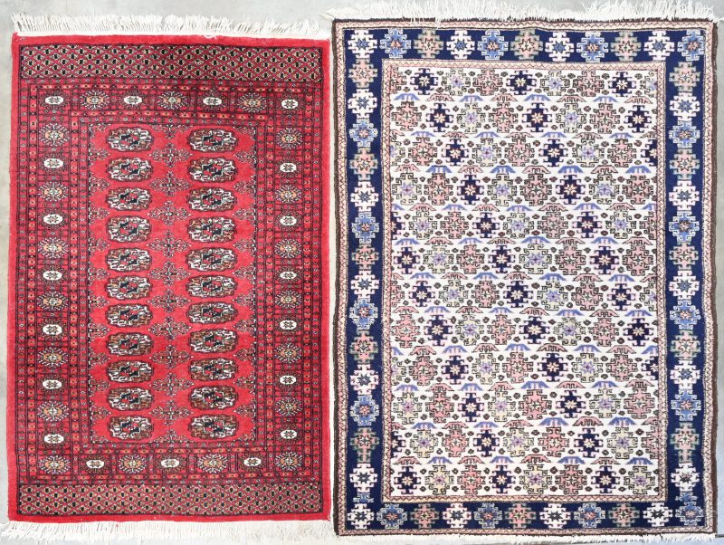 Een lot van twee handgeknoopte Perzische tapijtjes. 113/160 cm en 94/150 cm.