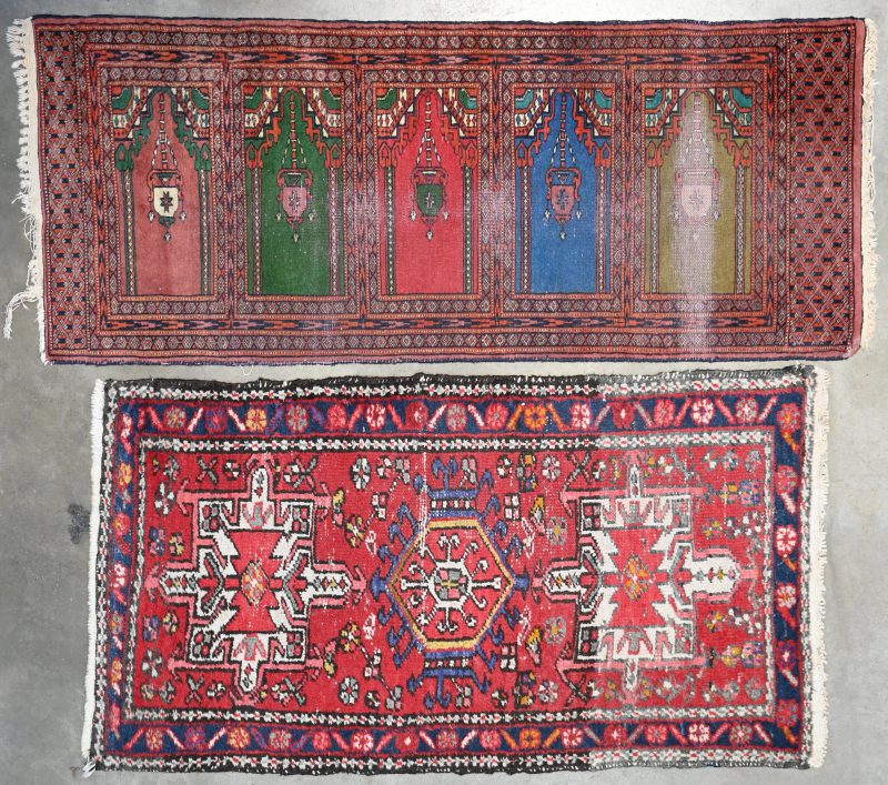 Een lot van twee handgeknoopte Perzische tapijtjes. 60/145 cm en 73/128 cm.