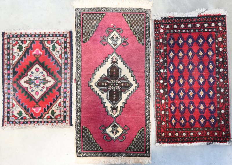 Een lot van drie handgeknoopte Perzische tapijtjes. 42/58 cm, 44/77 cm en 44/90 cm