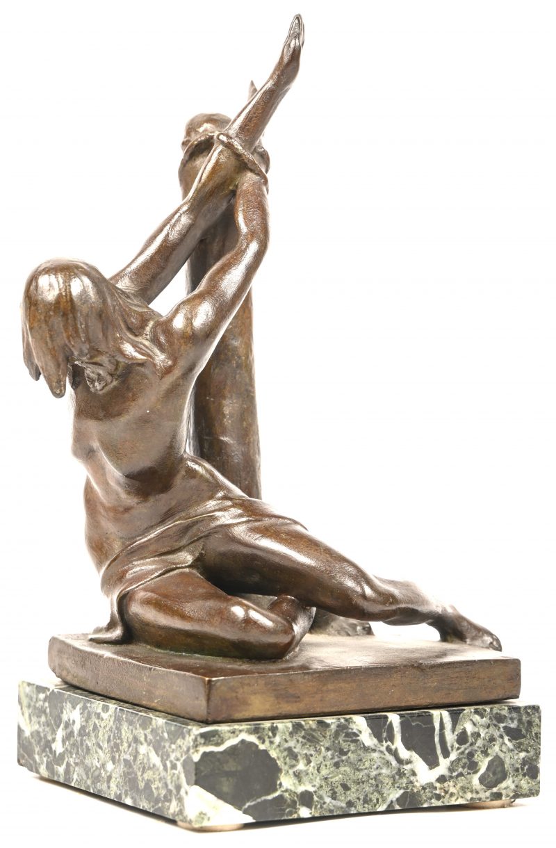 Een bronzen beeldje van een man met lendendoek, gekneveld aan een paal. Getekend; Dr. Tombeur. Gemonteerd op een groen marmeren voetje.