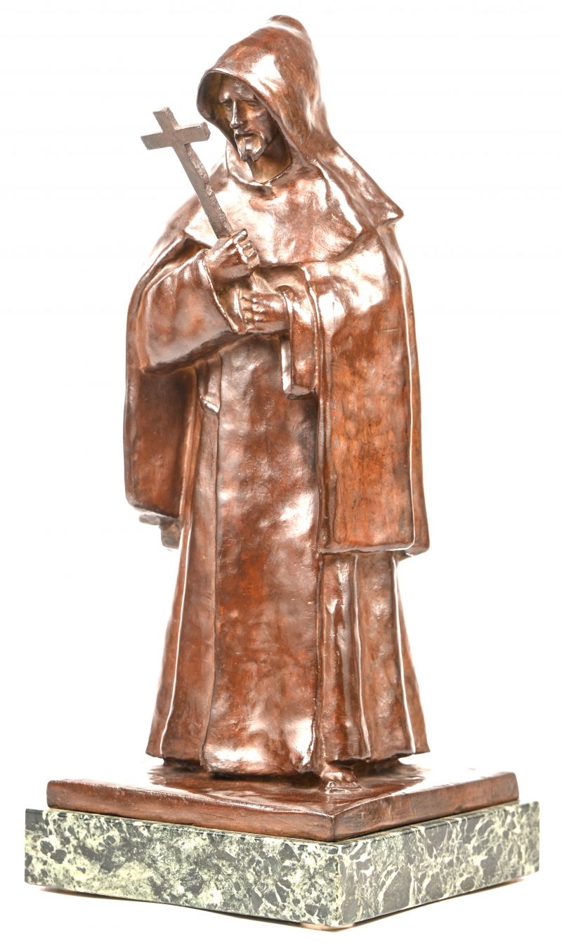 Een bronzen beeldje van een monnik met een kruisbeeld. Gemonteerd op een groen marmeren voetje. Niet getekend.