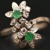 Een 18 kt witgouden ring bezet met diamanten met een gezamenlijk gewicht van +- 0,40 ct. en twee smaragden met een gezamenlijk gewicht van +- 0,20 ct.