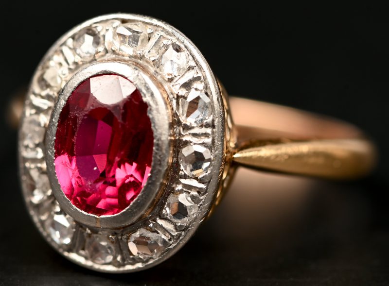 Een 14 kt wit en geelgouden ring bezet met diamanten oude slijp met een gezamenlijk gewicht van +- 0,30 ct. en een centrale spinel van +- 1 ct.