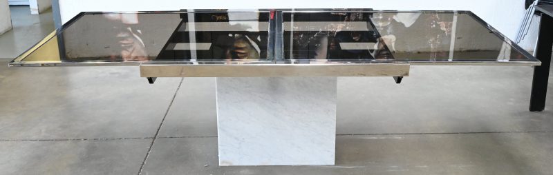 Een verlengbare vintage designtafel. Fumee glazen tafelbladen in een verchroomd frame, op een wit marmeren centrale poot. Verlengbaar tot 2,56 m.