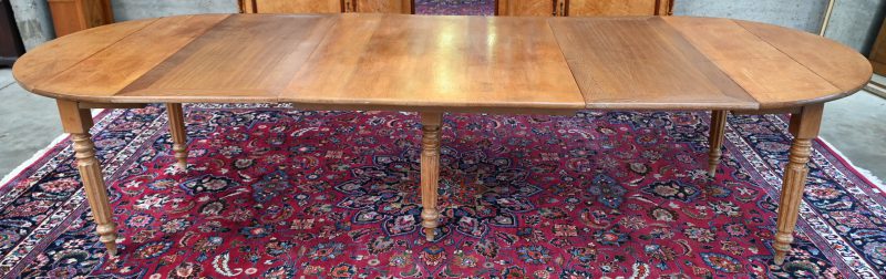 Een ronde massief houten tafel in Louis XVI stijl. Verlengbaar tot 3,27 m.