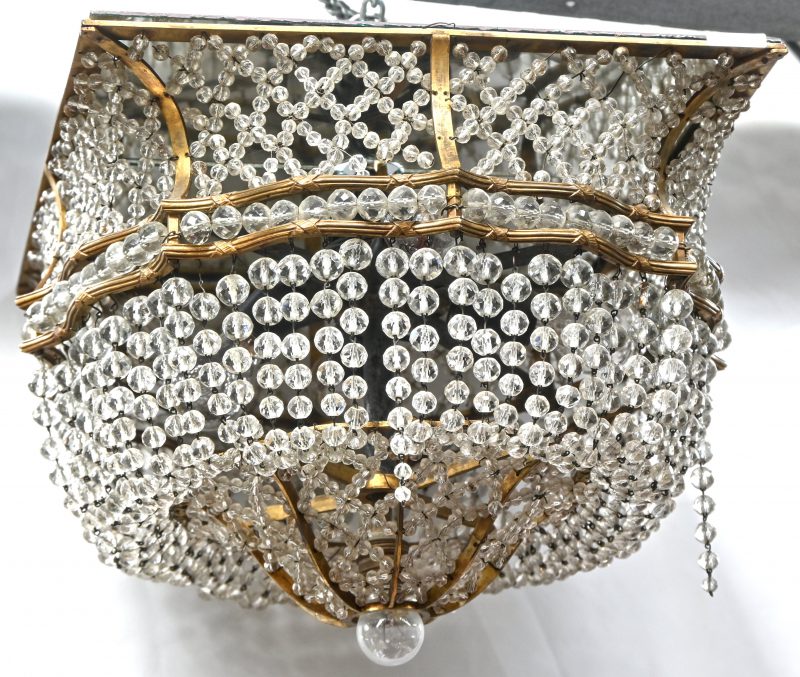 Een vierkante sac-à-perles luchter van koper en kristal met bovenin een spiegel.