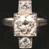 Een 18 kt witgouden ring bezet met centrale diamant van +- 2,10 ct. en twee diamanten met een gezamenlijk gewicht van +- 0,40 ct.