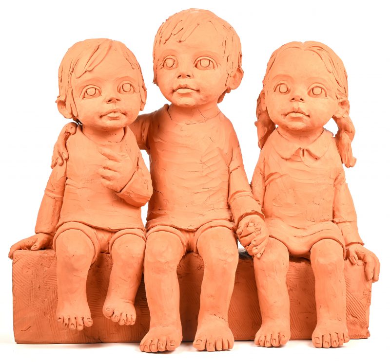 Een terracotta groep voorstellend 3 gezeten kinderen, gesigneerd May Claerhout.