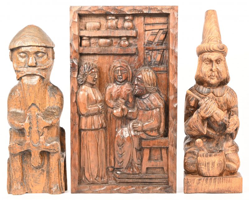 Een lot van twee houten beeldjes en een bas-relief met de voorstelling van kwakzalvers.