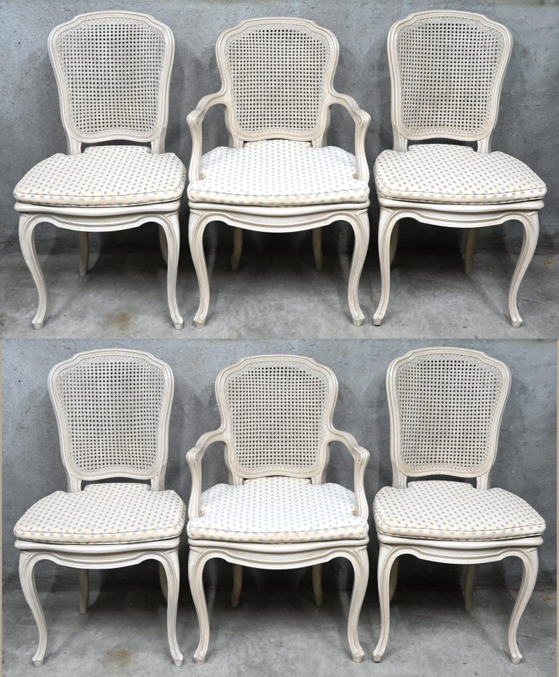 Een set van zes stoelen waarvan twee met armen, stijl Louis Philippe. Met cannage zit en rug en bijpassende kussens. Van lichtbruin geschilderd en gepatineerd hout.