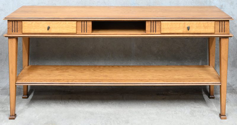 Een massieve eikenhouten consoletafel met onderblad en twee laden.