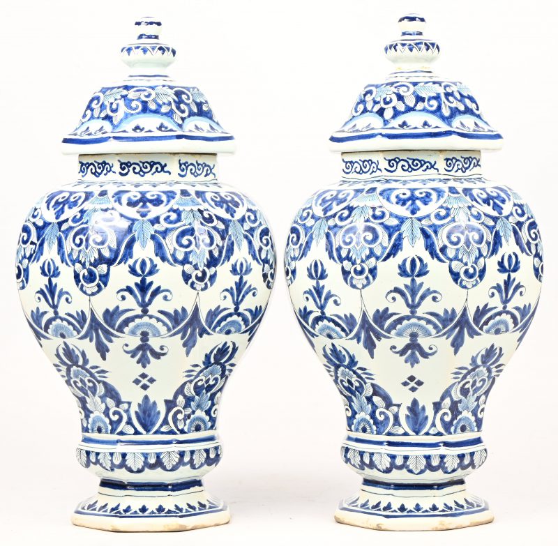 Een set octagonale dekselvazen van blauw-wit geglazuurd aardewerk. Getekend met de initialen H.V. Bij één vaas is de dekselknop gelijmd.