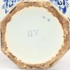 Een set octagonale dekselvazen van blauw-wit geglazuurd aardewerk. Getekend met de initialen H.V. Bij één vaas is de dekselknop gelijmd.