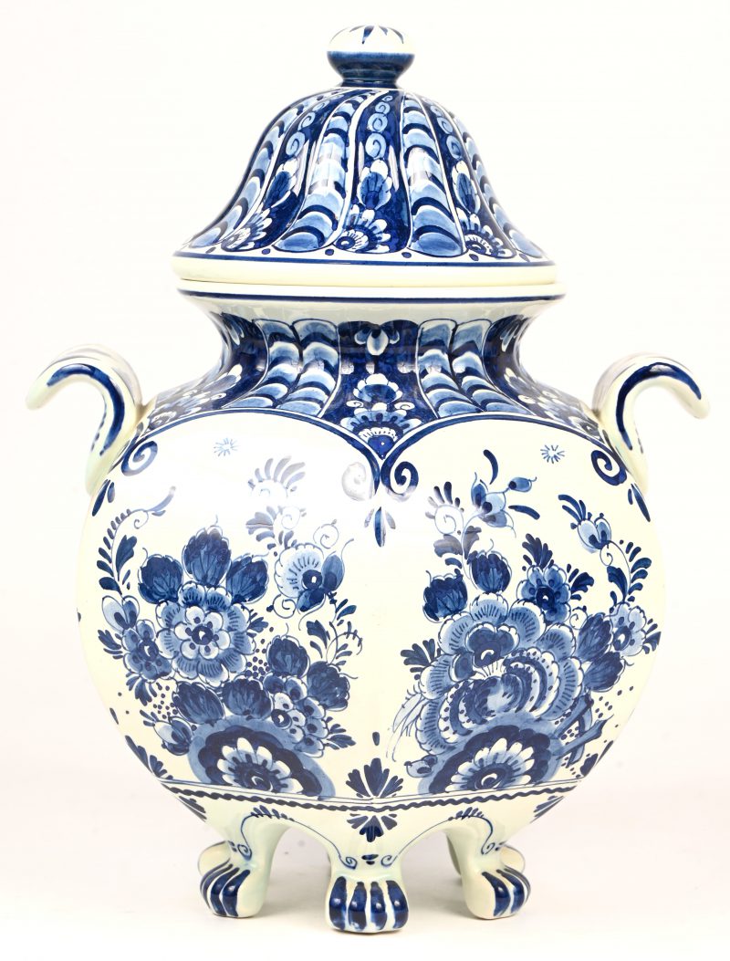 Een zeskantige dekselvaas op pootjes, van blauw-wit Delfts aardewerk.