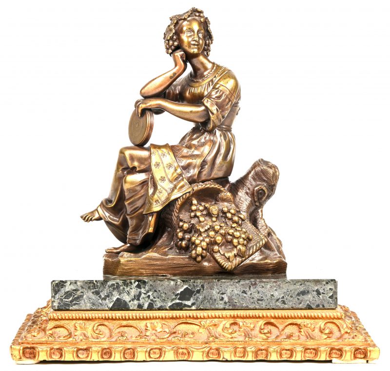 ‘Zittende Bacchante met tamboerijn’, een bronzen beeldje op marmeren voet. Niet getekend, draagt achteraan het nr. 5657.