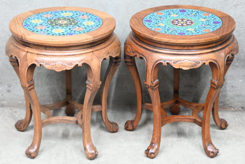 Een paar houten Aziatische bijzettafeltjes met cloisonné inleg. Met floraal decor.